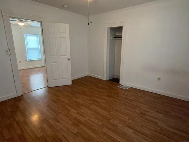 an empty room with wooden floor and closet