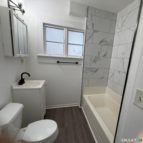 a bathroom with a sink and bathtub with toilet
