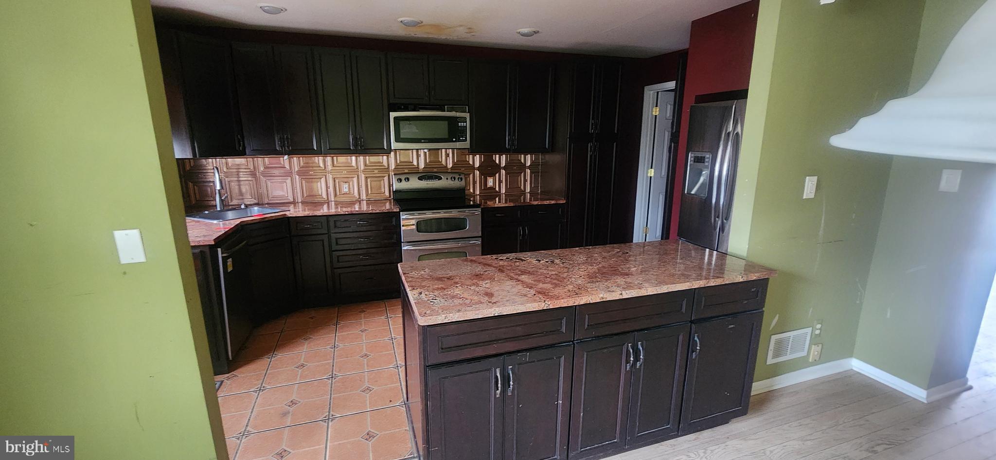 3612 Rockberry Road Baltimore, MD 21234 - Photo 8 of 22 a kitchen with kitchen island stainless steel appliances a sink stove and refrigerator