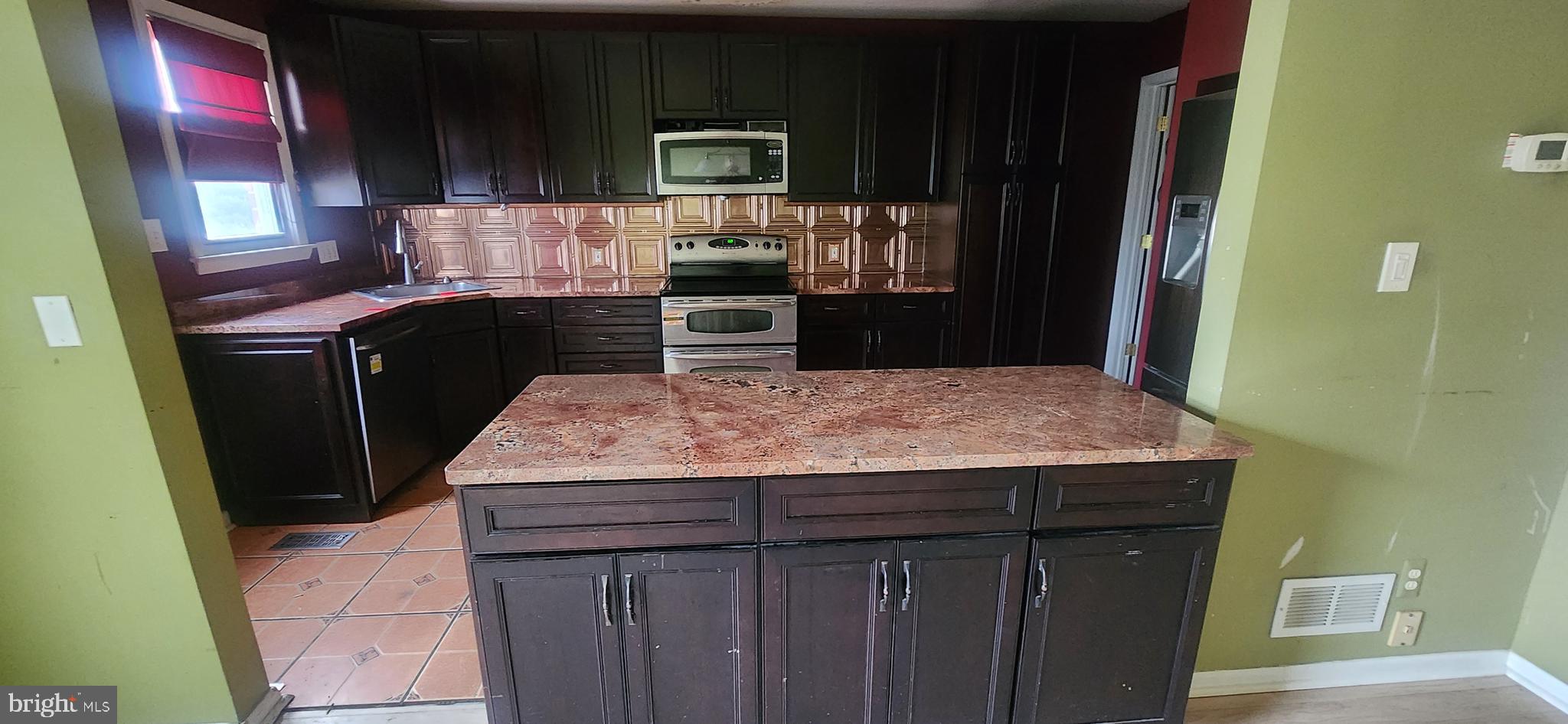 3612 Rockberry Road Baltimore, MD 21234 - Photo 9 of 22 a kitchen with a sink a microwave a refrigerator and cabinets