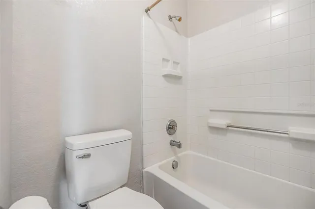 a spacious bathroom with a granite countertop sink toilet and shower