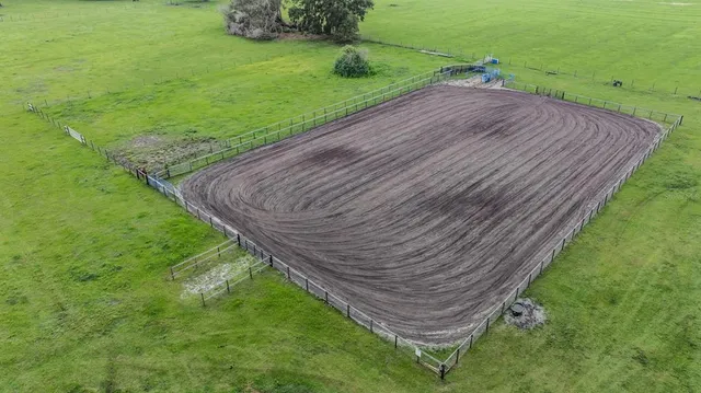 an aerial view of residential house with outdoor space and trees all around
