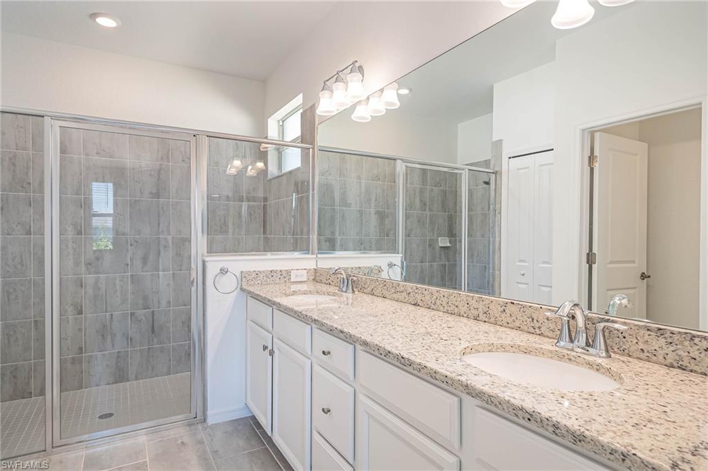 2418 Orchard Street Naples, FL 34120 - Photo 16 of 35 Bathroom with tile patterned floors, vanity, and an enclosed shower
