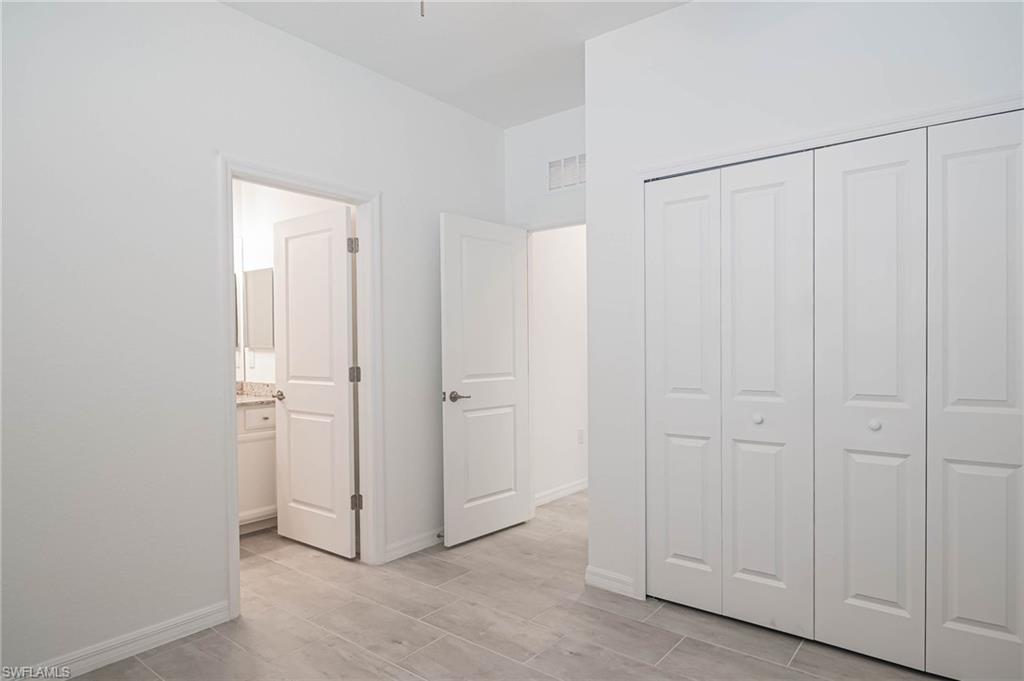 2418 Orchard Street Naples, FL 34120 - Photo 20 of 35 Unfurnished bedroom with ensuite bath and a closet