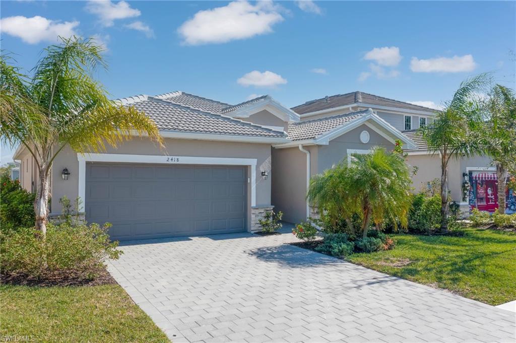 2418 Orchard Street Naples, FL 34120 - Photo 2 of 35 View of front of house featuring a front lawn and a garage