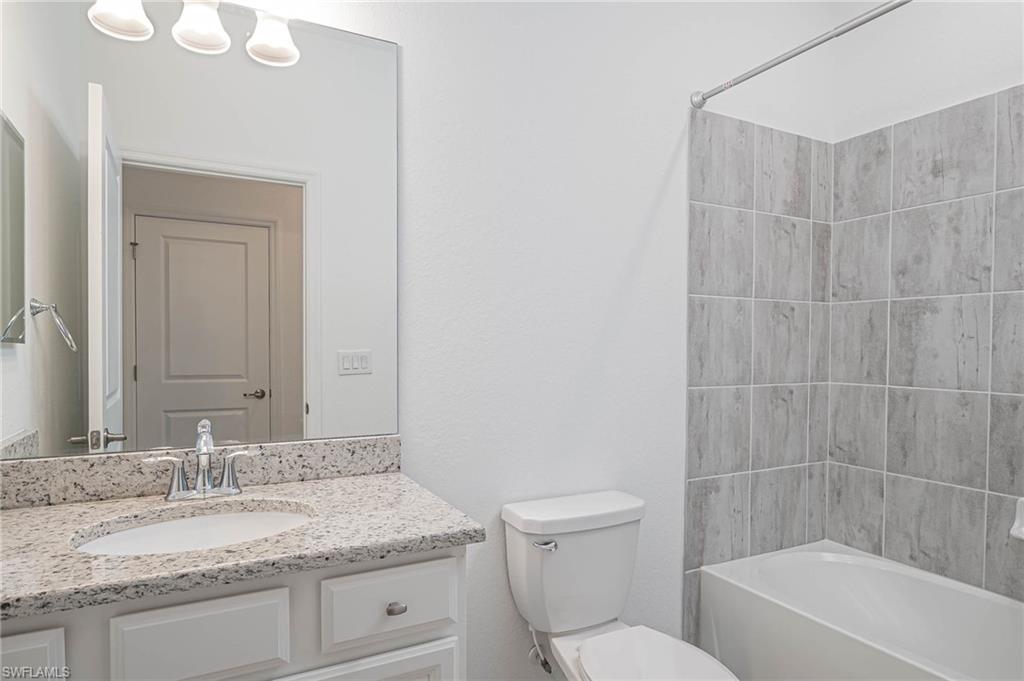 2418 Orchard Street Naples, FL 34120 - Photo 23 of 35 Full bathroom featuring toilet, vanity, and washtub / shower combination