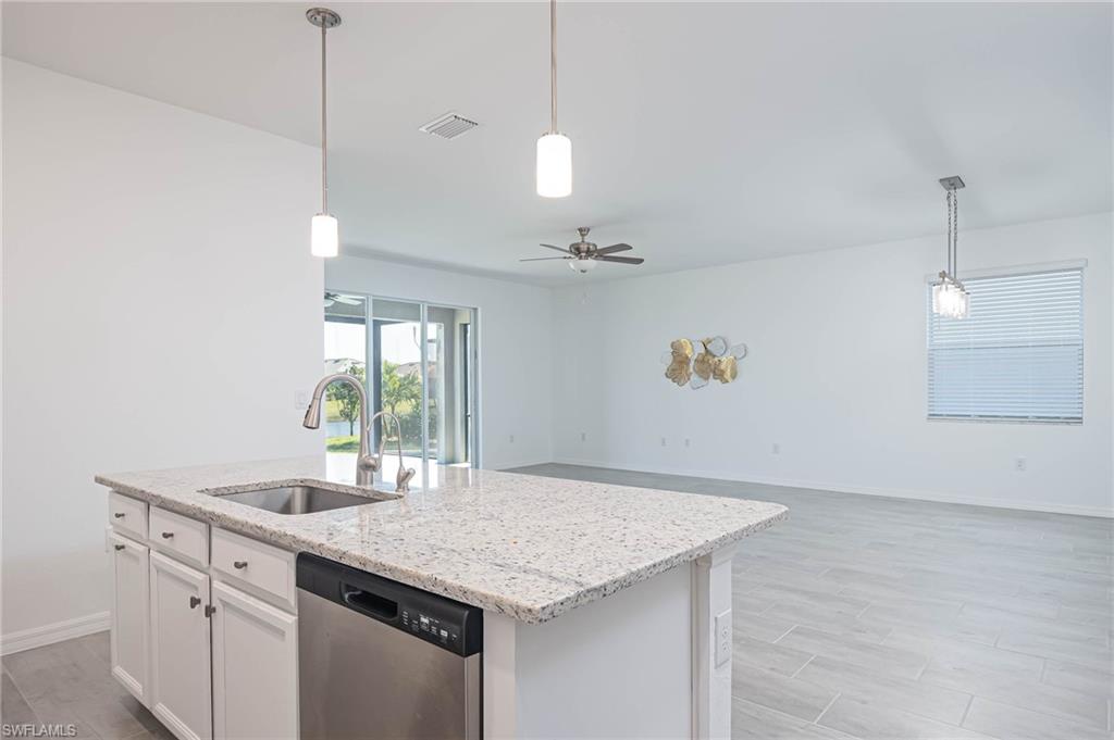 2418 Orchard Street Naples, FL 34120 - Photo 10 of 35 Kitchen featuring white cabinetry, dishwasher, ceiling fan, sink, and a center island with sink
