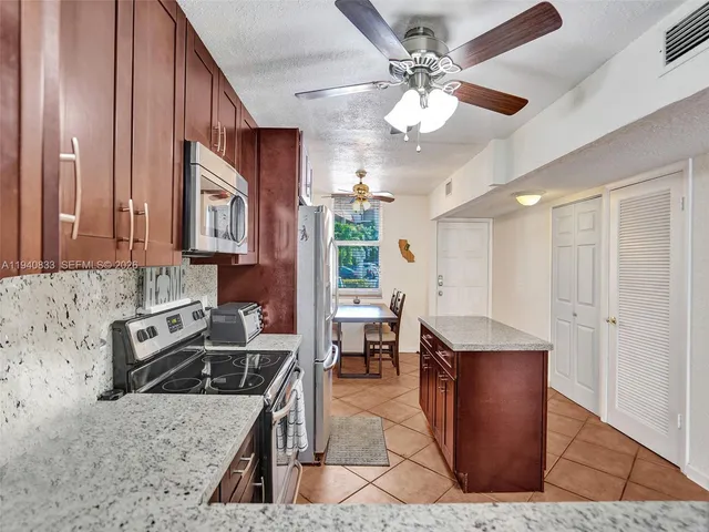 a kitchen with stainless steel appliances granite countertop a sink dishwasher stove and refrigerator
