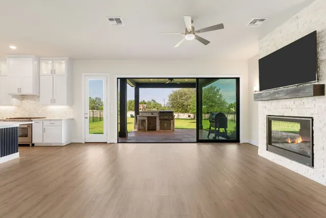 a view of an empty room with a fireplace and a flat screen tv