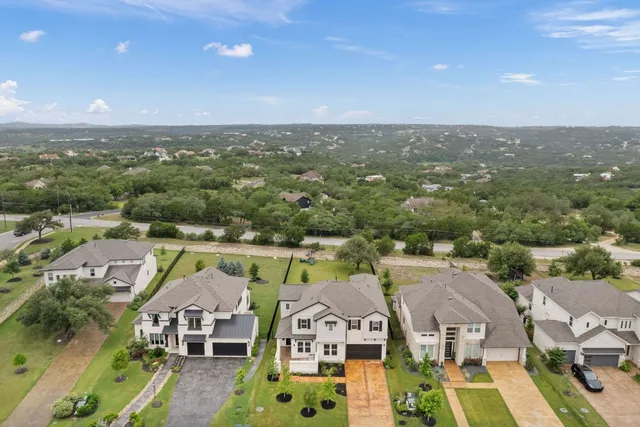 an aerial view of residential houses with outdoor space and parking