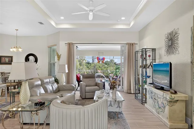 a living room with furniture a flat screen tv and a floor to ceiling window