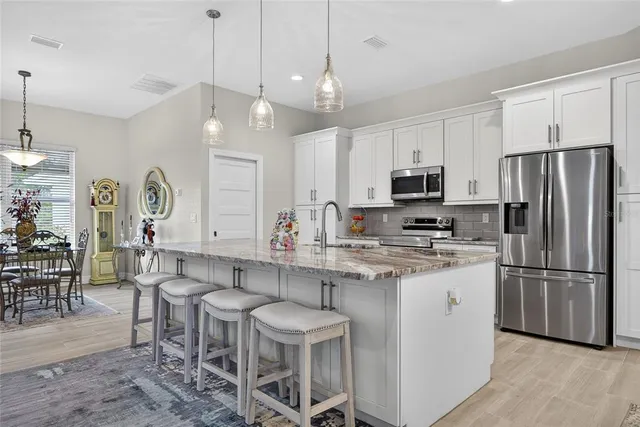a kitchen with kitchen island granite countertop a sink a center island and stainless steel appliances