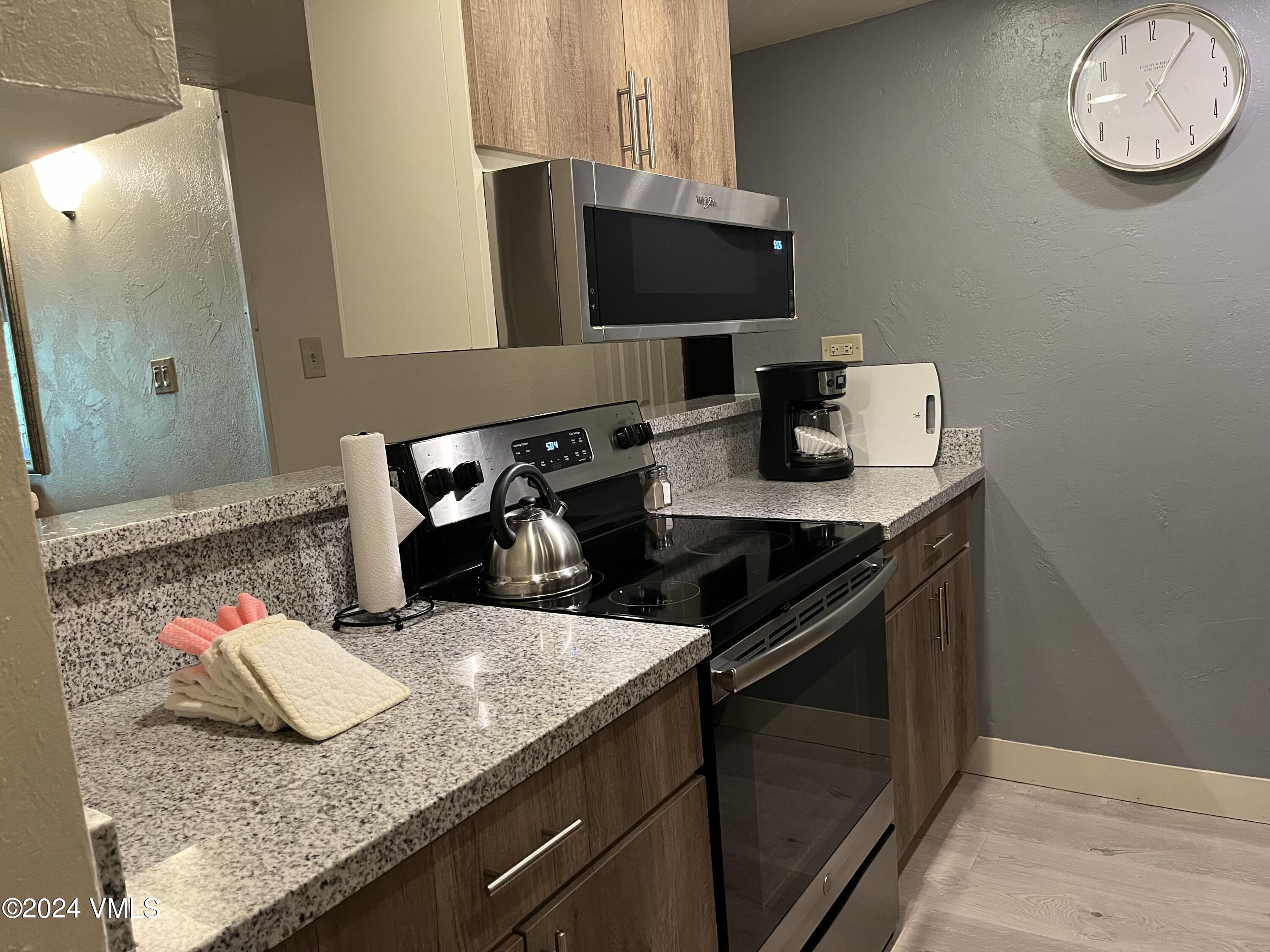 1020 Vail View Drive, Unit 131237 Vail, CO 81657 - Photo 19 of 20 a kitchen with a granite countertop sink and a stove top oven