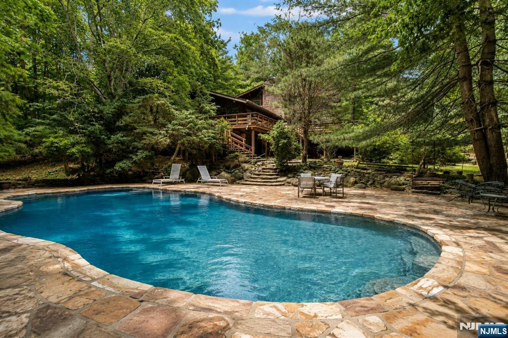 34 Cambridge Way Alpine, NJ 07620 - Photo 40 of 48 a swimming pool with outdoor seating and yard