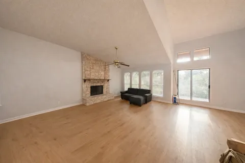 an empty room with wooden floor and fireplace