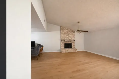 a view of empty room with fireplace and fan