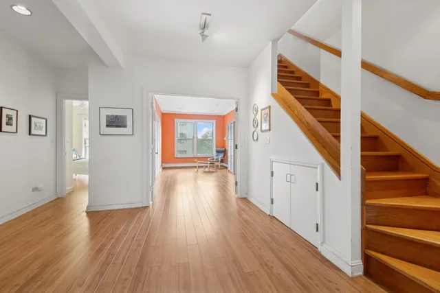 a view of a hallway with wooden floor and staircase