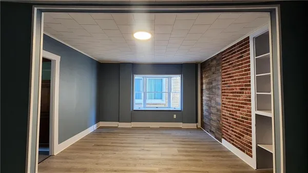 a view of empty room with window and wooden floor