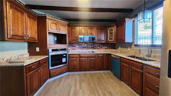 a kitchen with stainless steel appliances granite countertop wooden cabinets a sink and a stove
