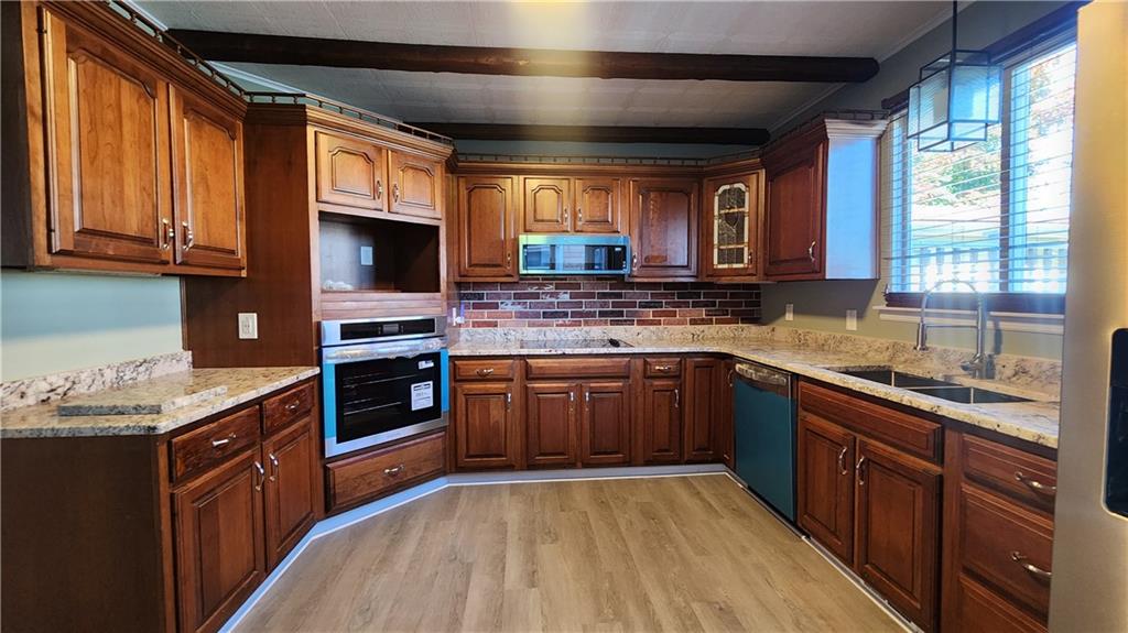 410 Longfellow Street Vandergrift, PA 15690 - Photo 9 of 25 a kitchen with stainless steel appliances granite countertop wooden cabinets a sink and a stove
