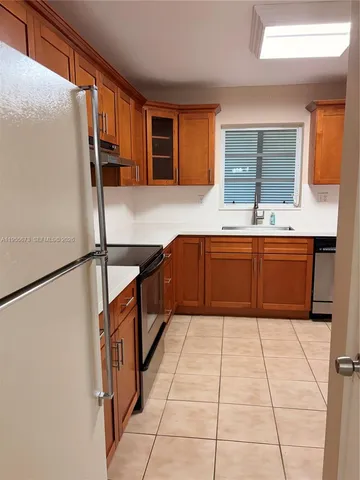 a kitchen with stainless steel appliances granite countertop a sink and a refrigerator