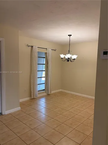 an empty room with kitchen and window