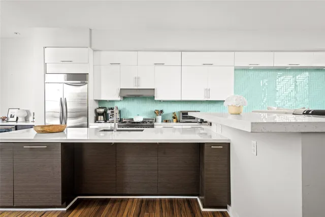a kitchen with stainless steel appliances granite countertop a stove a sink and white cabinets