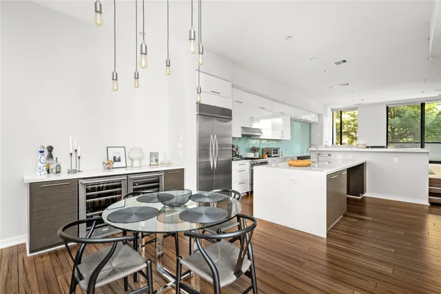 a kitchen with stainless steel appliances kitchen island a table and chairs in it
