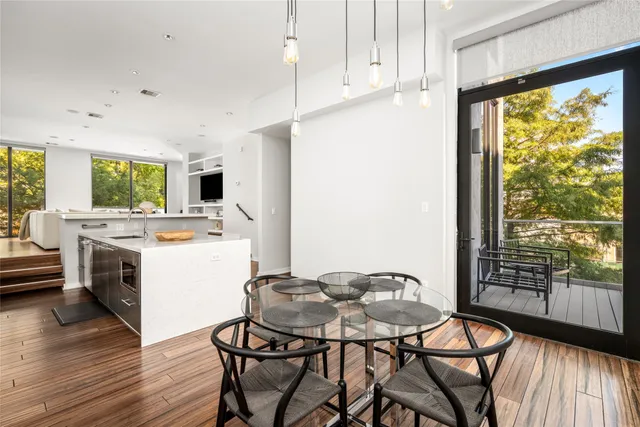 a kitchen with a table chairs a stove a microwave and a dining table