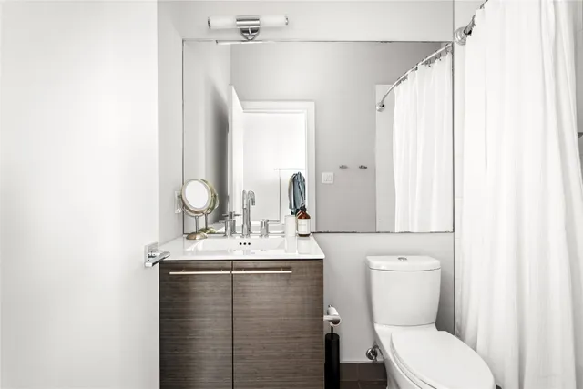a bathroom with a toilet sink and mirror