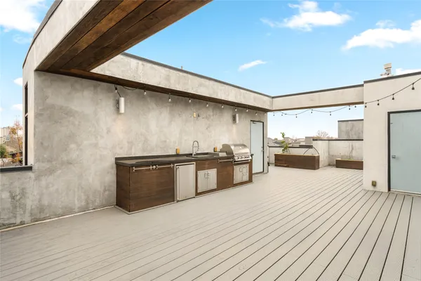 a large kitchen with stainless steel appliances wooden floor and a large window