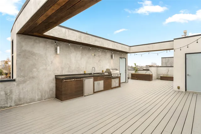 a large kitchen with stainless steel appliances wooden floor and a large window
