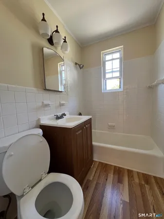 a bathroom with a granite countertop toilet sink and mirror
