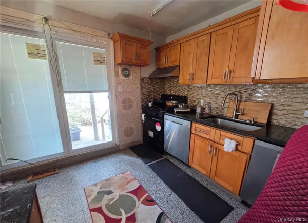 a kitchen with stainless steel appliances granite countertop a stove a sink and a refrigerator