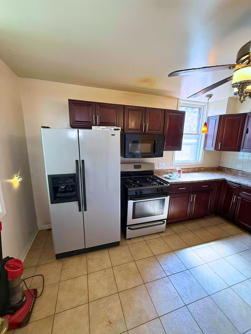 2038 West 70th Place Chicago, IL 60636 - Photo 4 of 8 a kitchen with stainless steel appliances a refrigerator and a stove top oven
