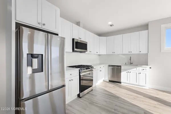 a kitchen with granite countertop a refrigerator stove and sink