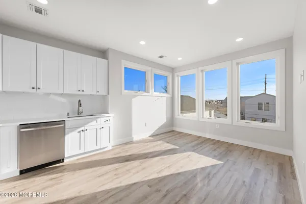 a kitchen with granite countertop a stove a sink and a refrigerator