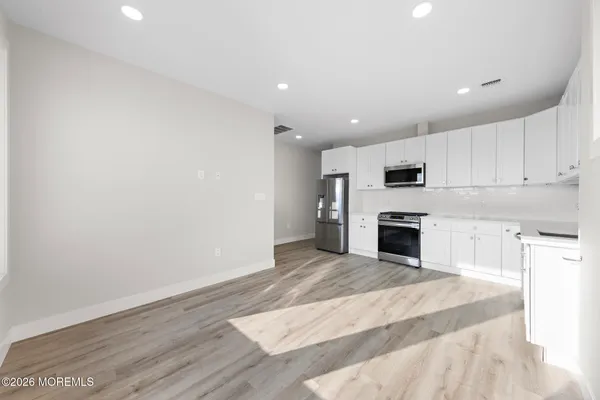 a view of kitchen with microwave and cabinets