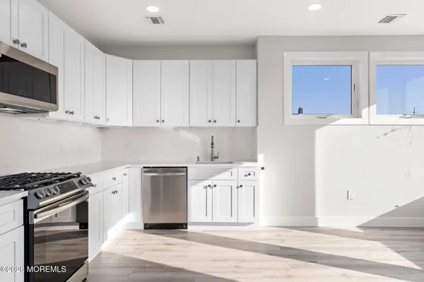 a kitchen with cabinets stainless steel appliances and a counter space