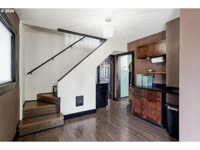 a living room with stainless steel appliances kitchen island furniture and wooden floor
