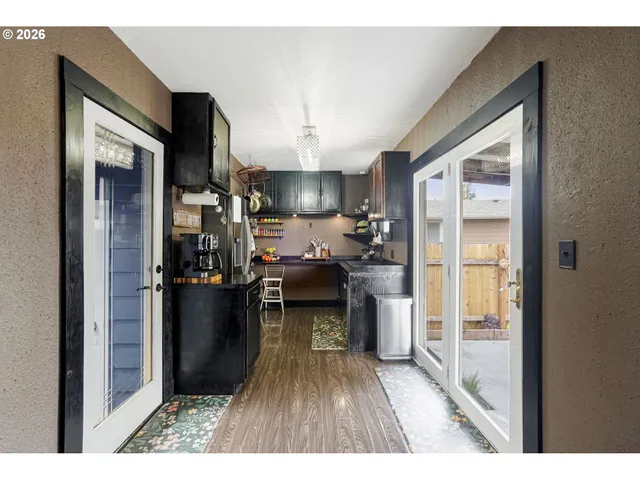 a kitchen with a refrigerator and a wooden floor