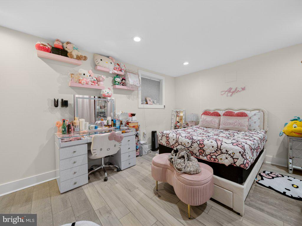 13427 Delaney Road Woodbridge, VA 22193 - Photo 52 of 57 a bedroom with a baby bed a desk and chair with wooden floor