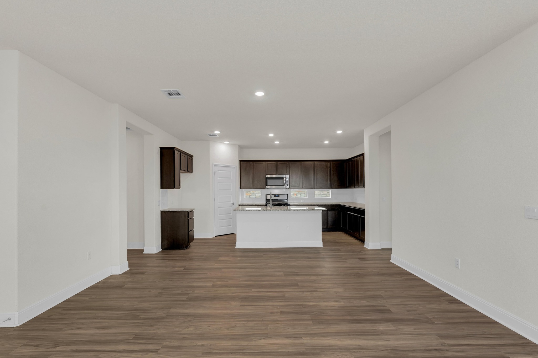 16817 Ponte Cove Pflugerville, TX 78660 - Photo 35 of 36 a view of kitchen with kitchen island a sink wooden floor and a living room view