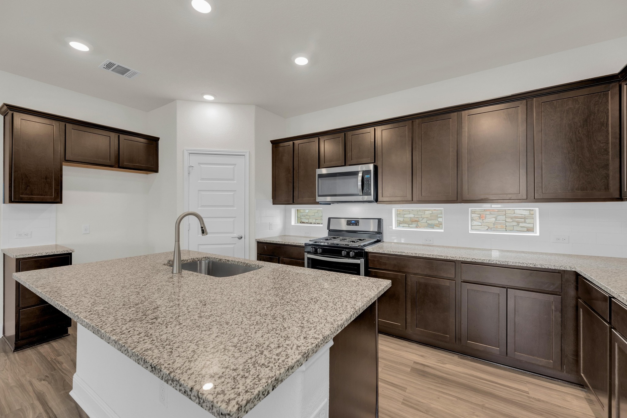 16817 Ponte Cove Pflugerville, TX 78660 - Photo 12 of 36 a kitchen with stainless steel appliances granite countertop a sink dishwasher a stove top oven a refrigerator with island and chairs