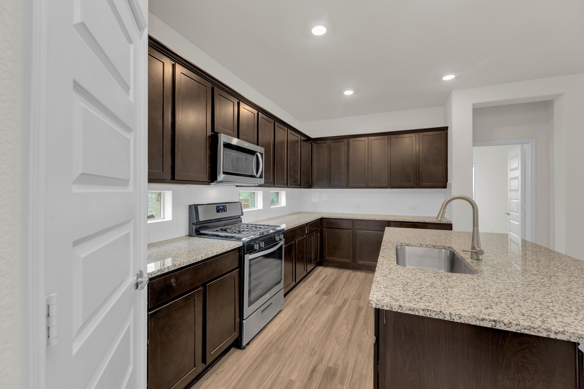 16817 Ponte Cove Pflugerville, TX 78660 - Photo 13 of 36 a kitchen with stainless steel appliances granite countertop a sink stove and microwave