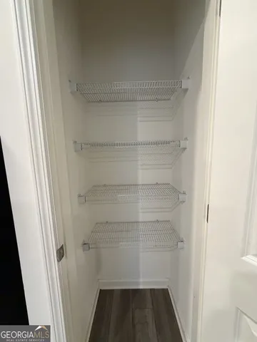 a view of walk in closet with empty racks