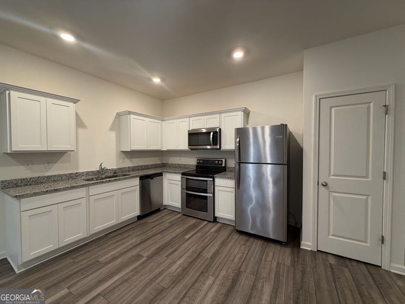 35300 Condor Court Southwest Atlanta, GA 30331 - Photo 9 of 31 a kitchen with stainless steel appliances granite countertop a refrigerator a stove top oven a sink and dishwasher with wooden floor