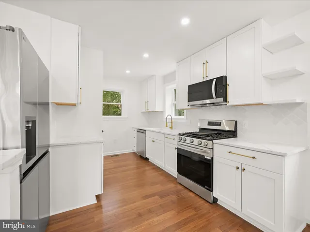 a kitchen with stainless steel appliances a stove a sink and a refrigerator