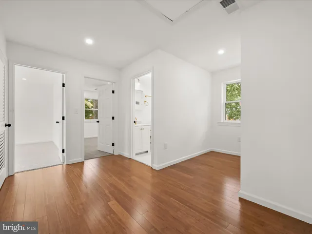 a view of an empty room with wooden floor
