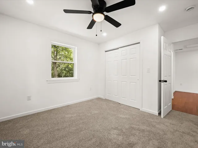 an empty room with a window and a ceiling fan